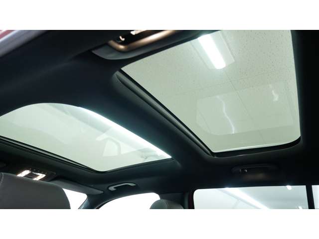 【パノラミックライディングルーフ】紫外線を効果的に遮るUVカットガラスを採用し、ウインドデフレクターも装備しています。ワンタッチ開閉機能、挟み込み防止装置も備わります。後部座席のガラスは開閉しません。
