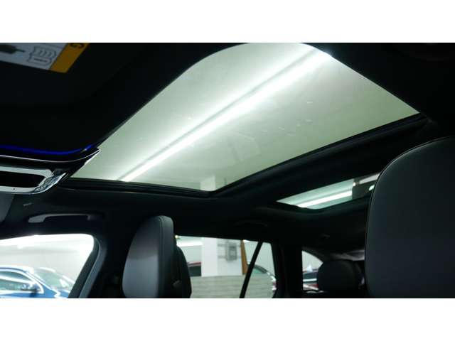 【パノラミックライディングルーフ】紫外線を効果的に遮るUVカットガラスを採用し、ウインドデフレクターも装備しています。ワンタッチ開閉機能、挟み込み防止装置も備わります。後部座席のガラスは開閉しません。